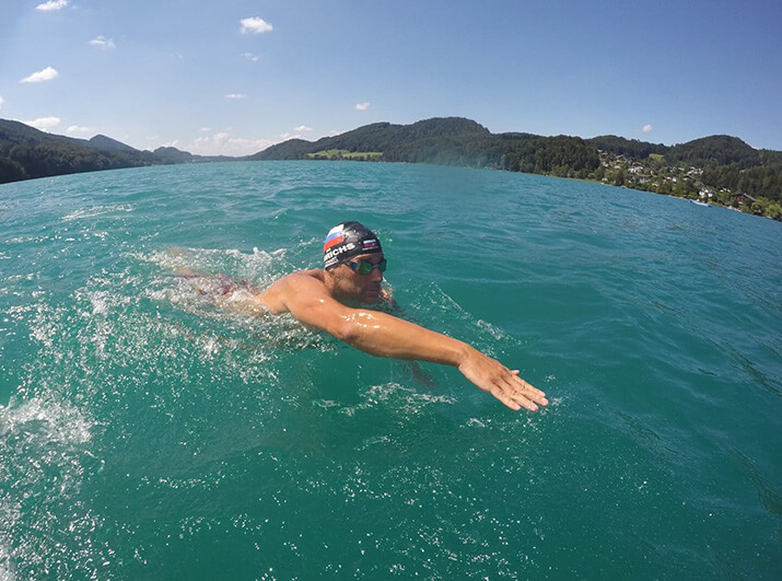 Schwimmexperte Marco Henrichs im Freiwasser mit Badekappe, macht einen Kraularmzug, hält den Kopf über Wasser Schwimmexperte Marco Henrichs im Freiwasser mit Badekappe, macht einen Kraularmzug, hält den Kopf über Wasser